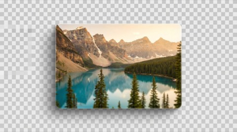 Golden hour landscape view of mountain range towering over turquoise lake with evergreen trees in foreground during sunset
