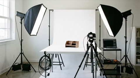 Minimalist product photography setup with wooden organizer on white background and professional studio lighting equipment